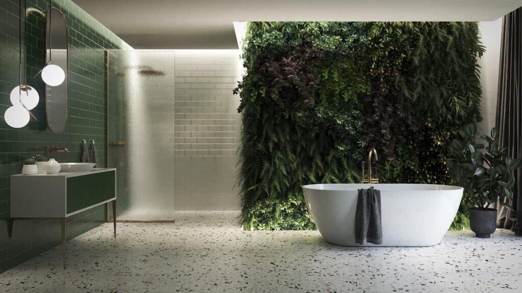 Salle de bain moderne avec mur végétal, baignoire îlot et carrelage vert émeraude. Sol terrazzo, douche en verre dépoli et meuble vasque design.
